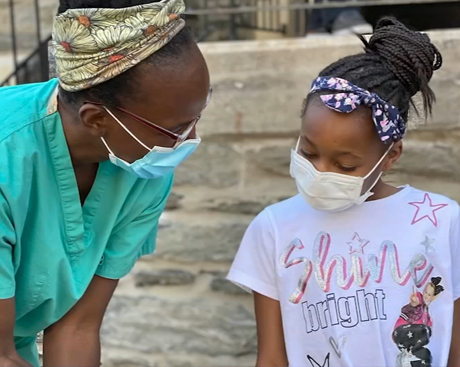 Dr. Ala Stanford helps child before vaccination shot
